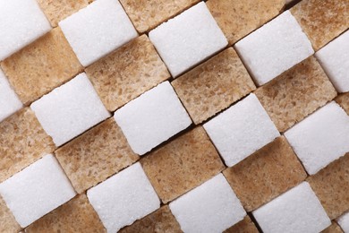 White and brown sugar cubes as background, top view