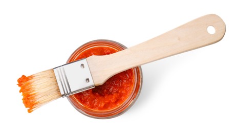 Photo of Fresh marinade in jar and basting brush isolated on white, top view