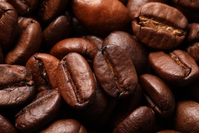 Photo of Aromatic roasted coffee beans as background, closeup