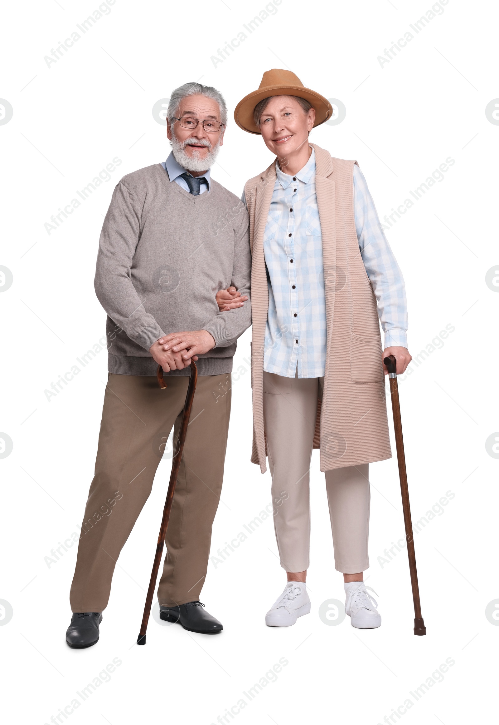 Photo of Senior man and woman with walking canes on white background