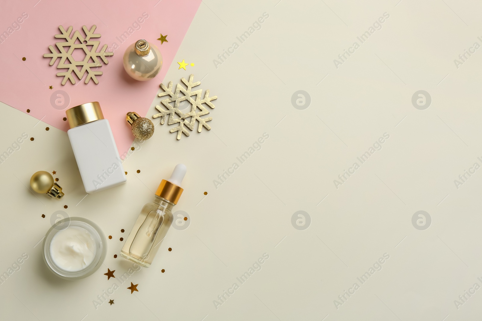 Photo of Flat lay composition with cosmetic products on pink and beige background. Winter care. Space for text
