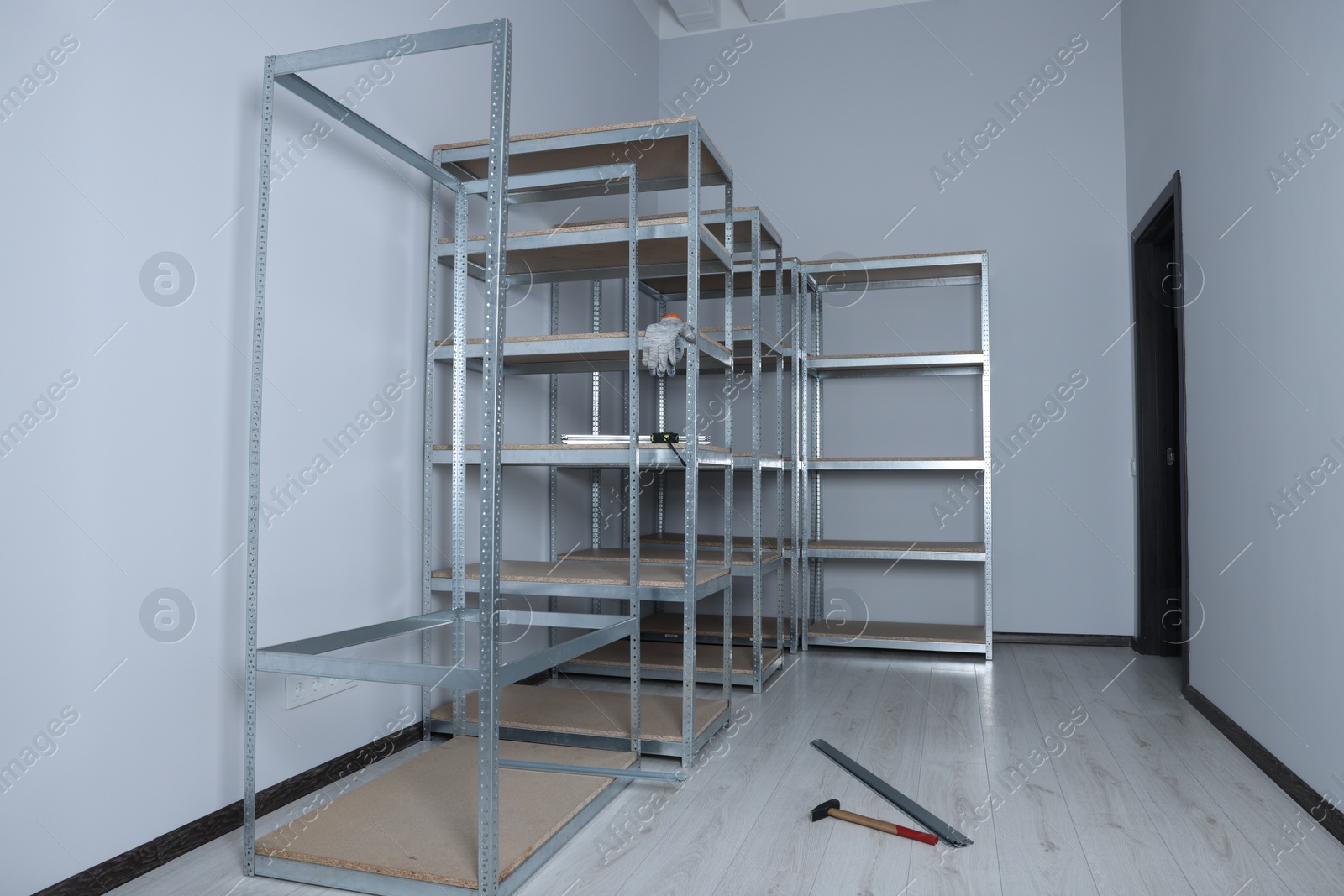 Photo of Office room with white walls and metal storage shelves