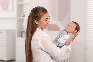 Mother holding her cute newborn baby at home