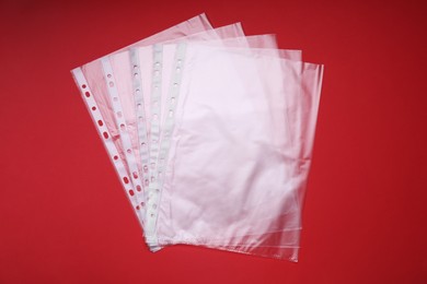 Photo of Punched pockets on red background, flat lay