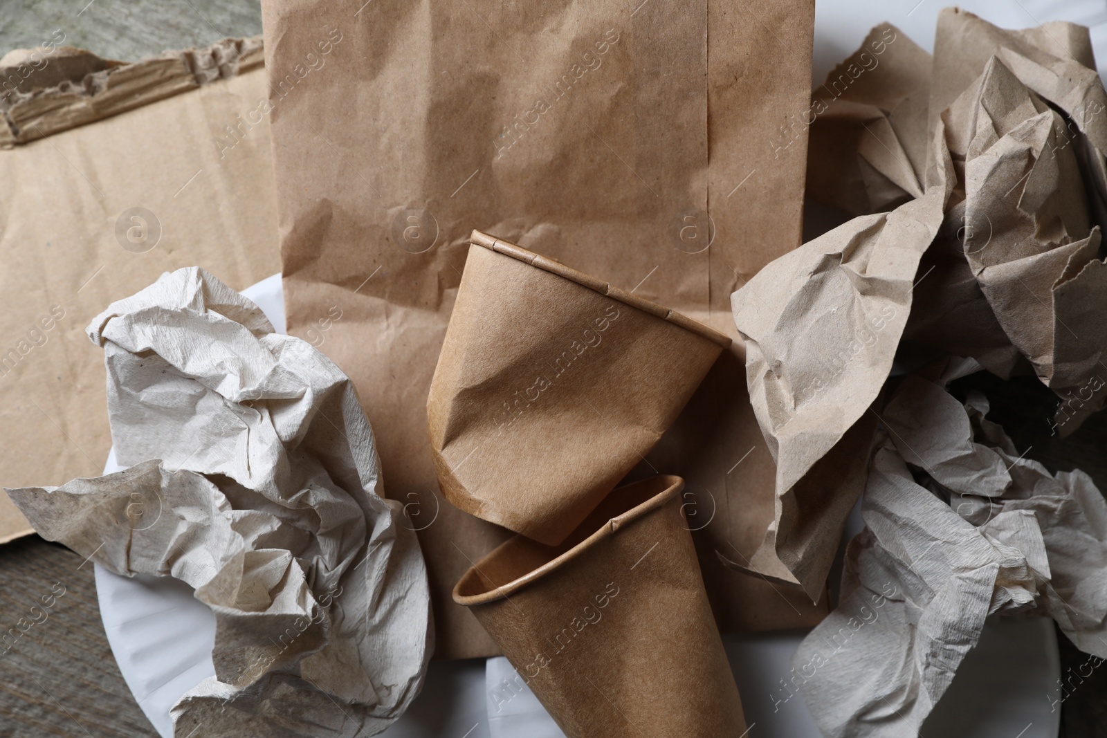 Photo of Different waste paper on wooden table, flat lay