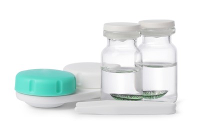 Photo of Color contact lenses, tweezers and bottles of solution isolated on white