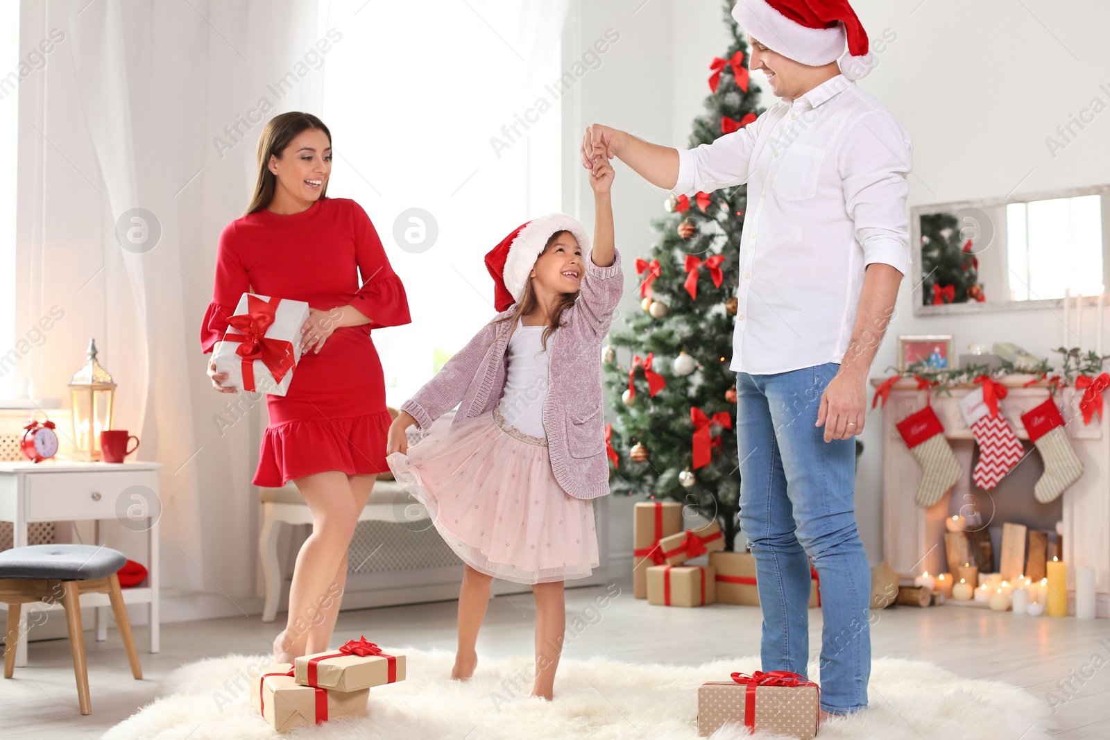Photo of Happy parents and child having fun near Christmas tree at home