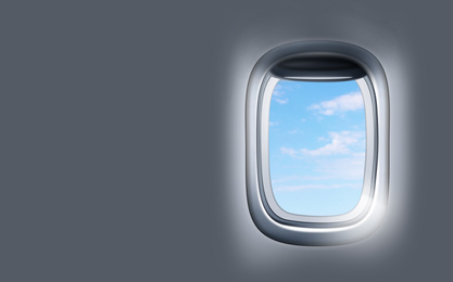 Image of View on blue sky through open airplane porthole. Space for text