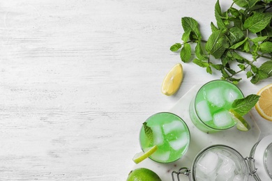 Photo of Flat lay composition with delicious cocktails on white wooden table. Space for text