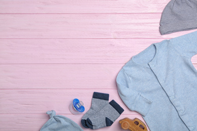 Photo of Flat lay composition with child's clothes on wooden background, space for text