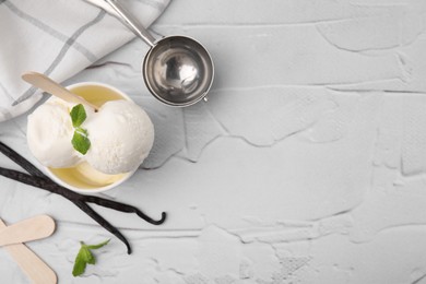Photo of Delicious vanilla ice cream served on white textured table, flat lay. Space for text