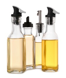 Photo of Different glass bottles with cooking oil on white background