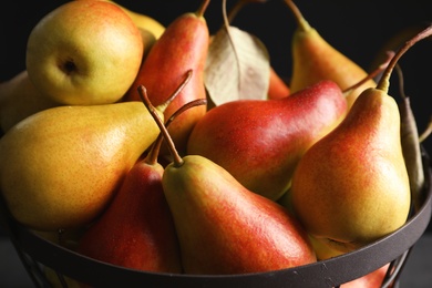 Photo of Basket with ripe pears on black background, closeup