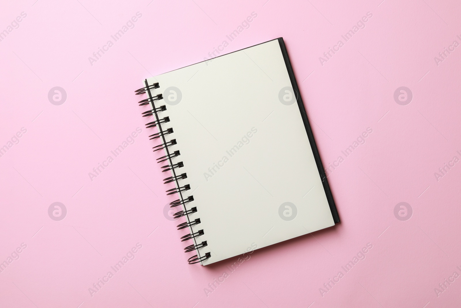 Photo of Blank notebook on pale pink background, top view