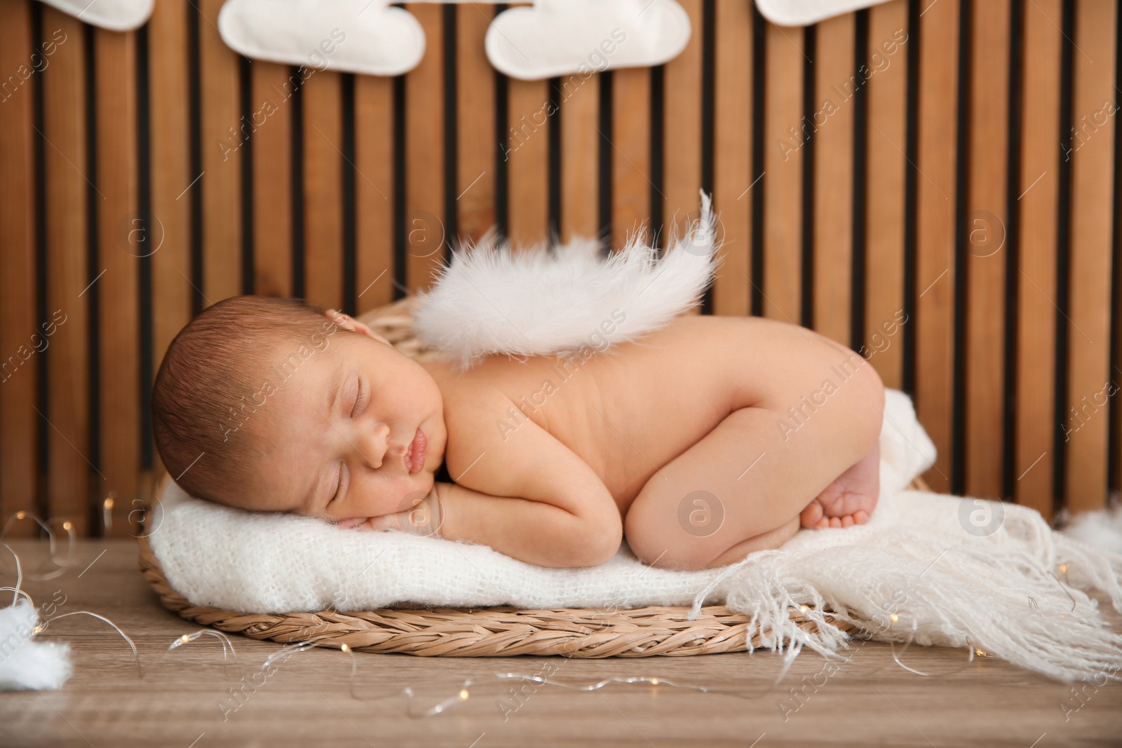 Photo of Cute newborn baby as Christmas angel in decorated studio