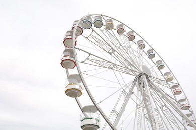 Photo of Large white observation wheel against sky, low angle view. Space for text