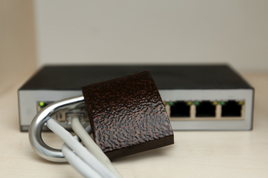 Photo of Wi-Fi router with padlock on shelf. Protection from cyber attack