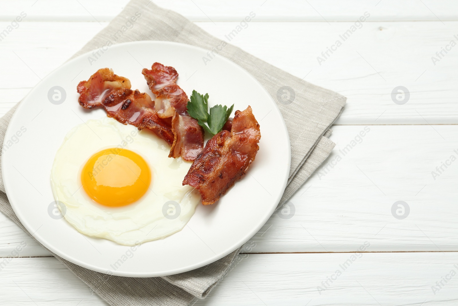 Photo of Delicious breakfast with sunny side up egg on white wooden table