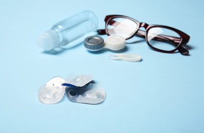 Photo of Contact lenses, glasses and accessories on color background
