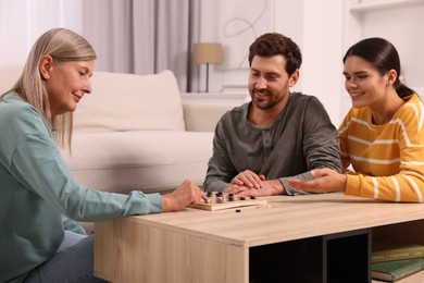 Family playing checkers at coffee table in room