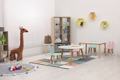 Photo of Stylish kindergarten interior with toys and modern furniture