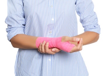 Photo of Young woman with hand wrapped in medical bandage on white background, closeup