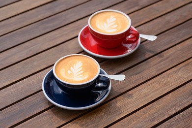 Photo of Cups of aromatic coffee on wooden table