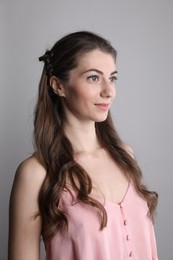 Woman with wavy hair on grey background