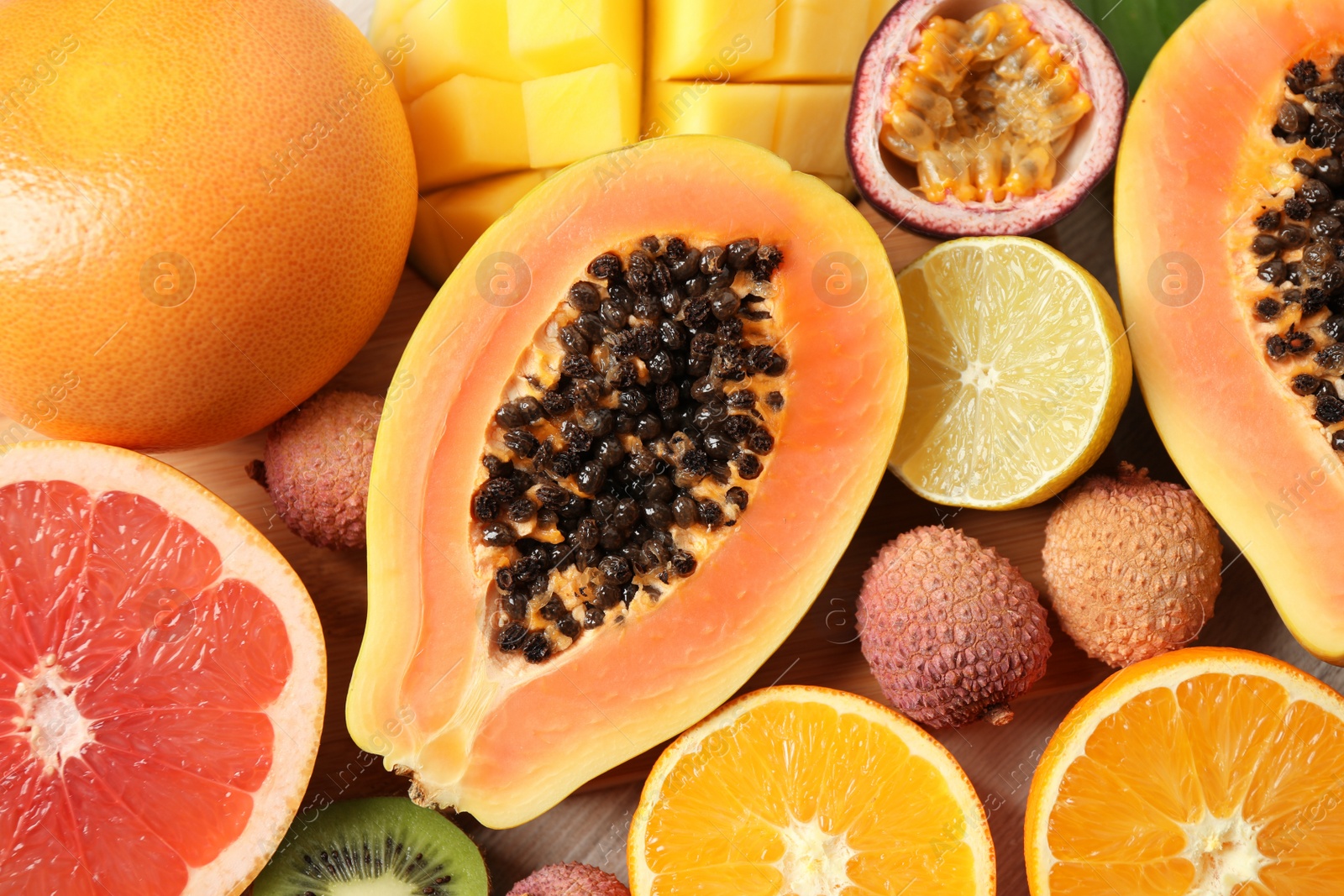 Photo of Fresh ripe papaya and other fruits on table, top view