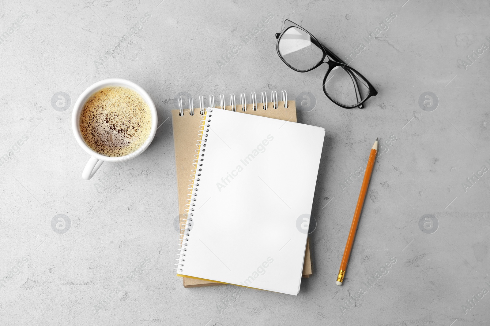 Photo of Flat lay composition with office stationery and cup of coffee on light stone background. Space for design