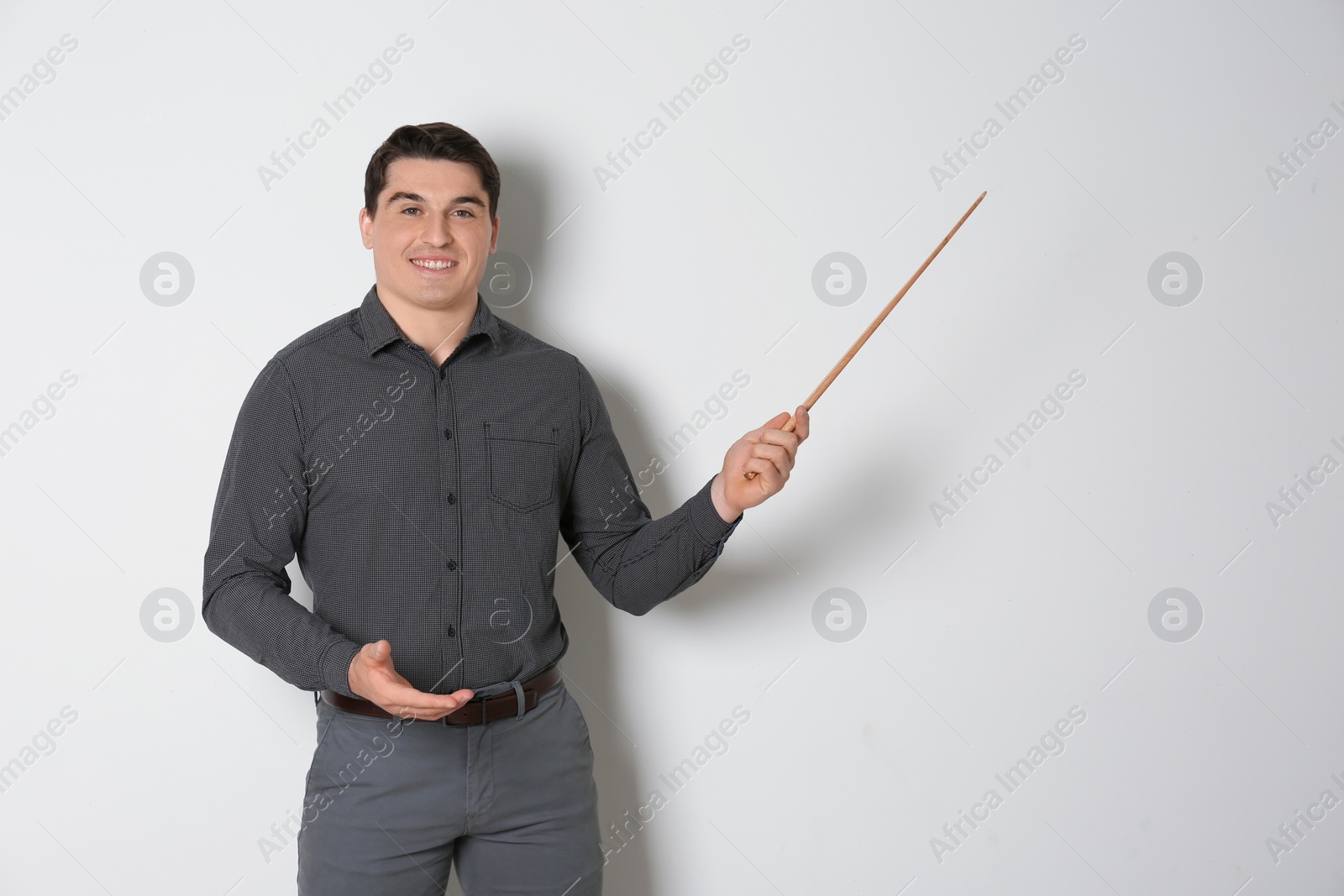 Photo of Portrait of male teacher with pointer on light background