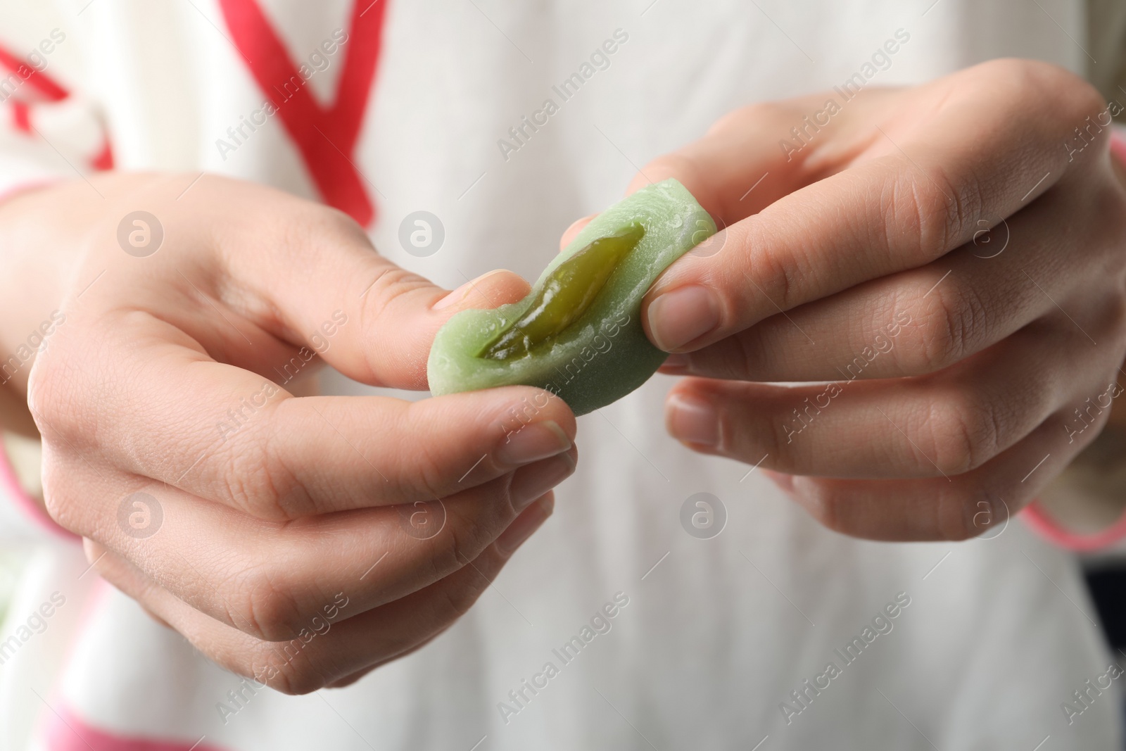 Photo of Woman holding delicious mochi, closeup. Japanese cuisine