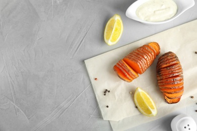 Photo of Flat lay composition with baked sweet potatoes on grey background. Space for text