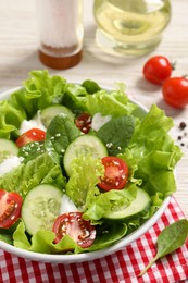Delicious salad in bowl on white table, closeup