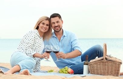 Happy romantic couple having picnic at beach
