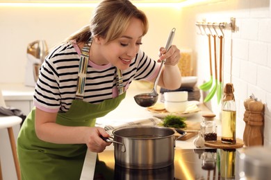 Woman making bouillon on stove in kitchen. Homemade recipe