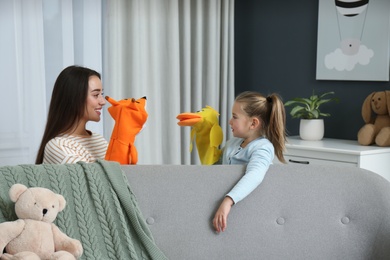 Photo of Mother and daughter performing puppet show at home