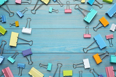 Photo of Binder clips on light blue background, flat lay. Space for text