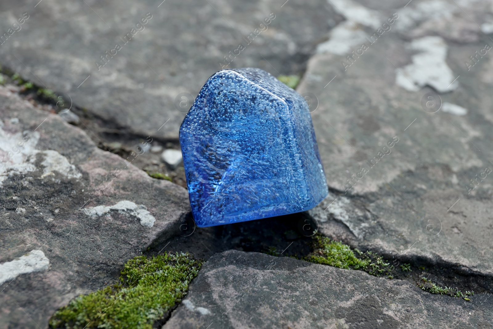 Photo of Glass house model between cracks on stone road. Earthquake disaster