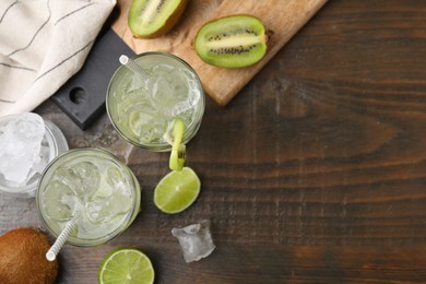 Photo of Glasses of refreshing drink with kiwi on wooden table, flat lay. Space for text