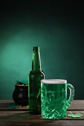 St. Patrick's day party. Green beer, leprechaun pot of gold and decorative clover leaves on wooden table