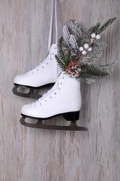 Pair of ice skates with Christmas decor hanging on wooden wall