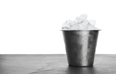 Photo of Metal bucket with ice cubes on table against white background