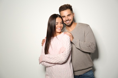 Image of Lovely couple in warm sweaters on light background 