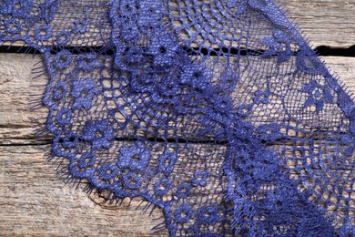 Photo of Beautiful lace on wooden table, top view