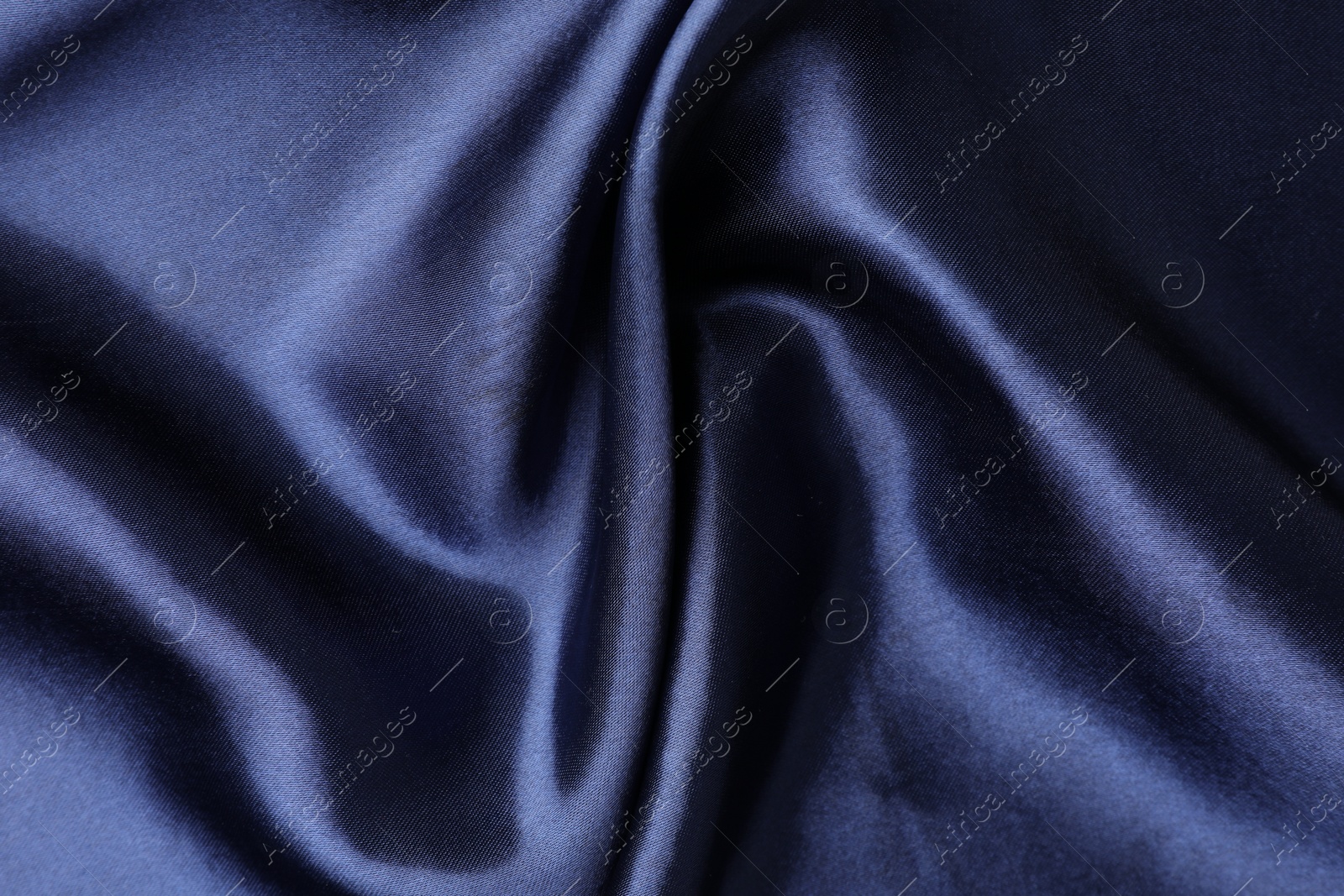 Photo of Crumpled dark blue silk fabric as background, top view