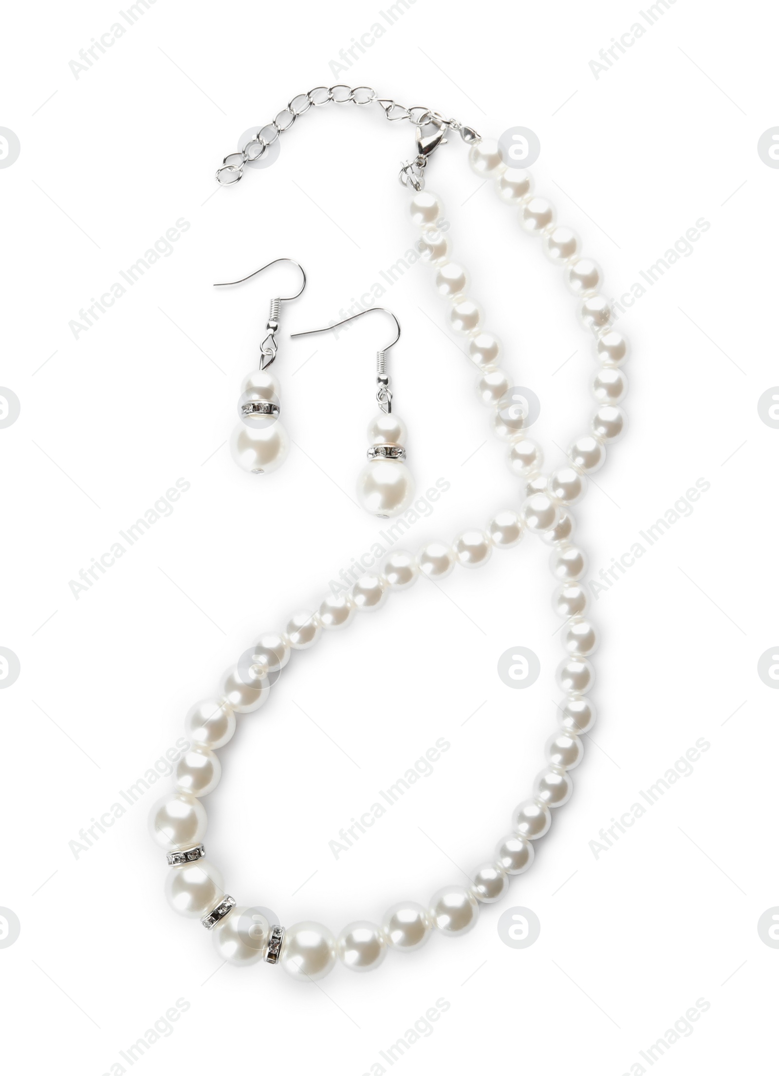 Photo of Elegant pearl necklace and earrings on white background, top view