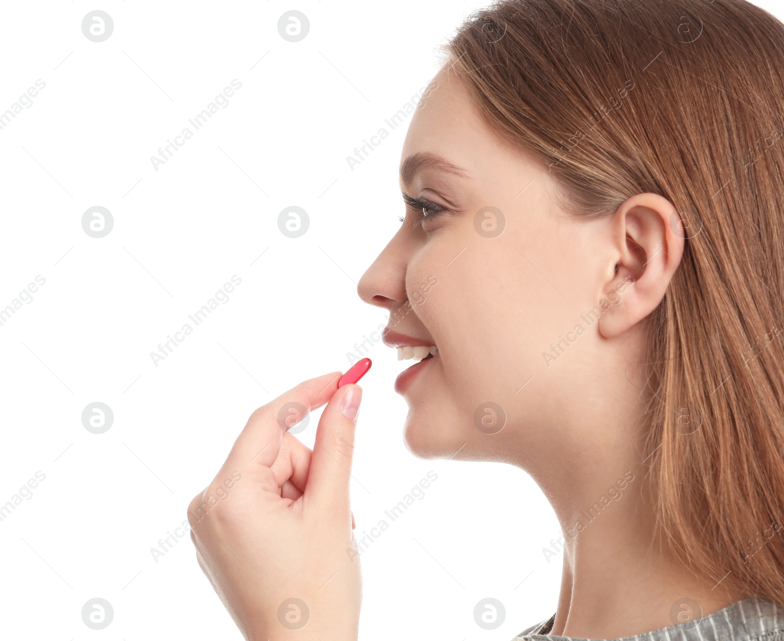 Photo of Young woman taking vitamin capsule on white background