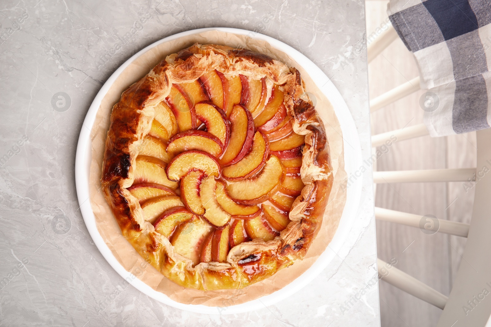 Photo of Delicious fresh peach pie on grey kitchen table, top view