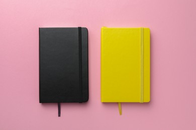 Photo of Different notebooks on light pink background, top view